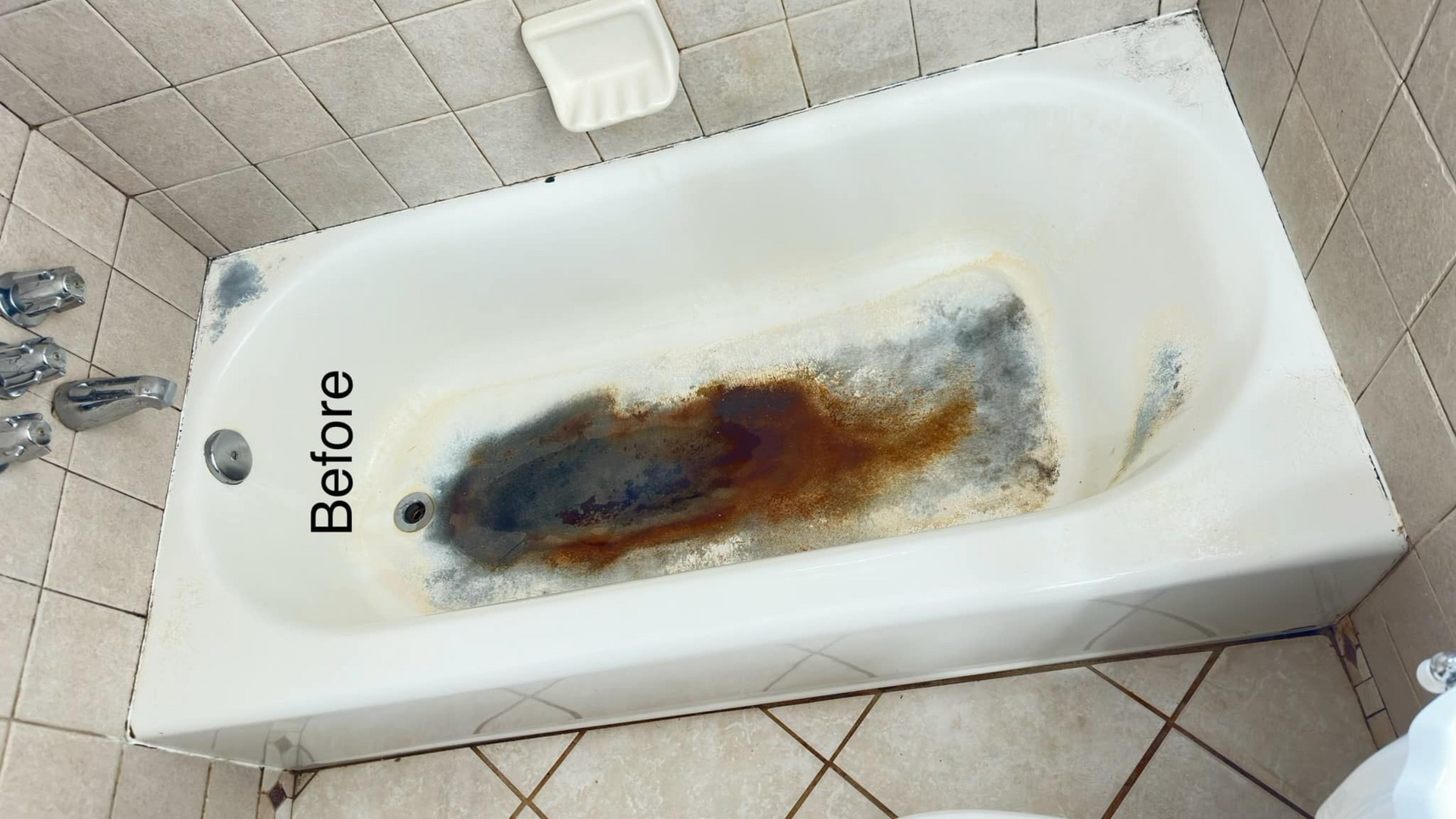 Bathtub before cleaning; stained with dark brown and black discoloration at the bottom.