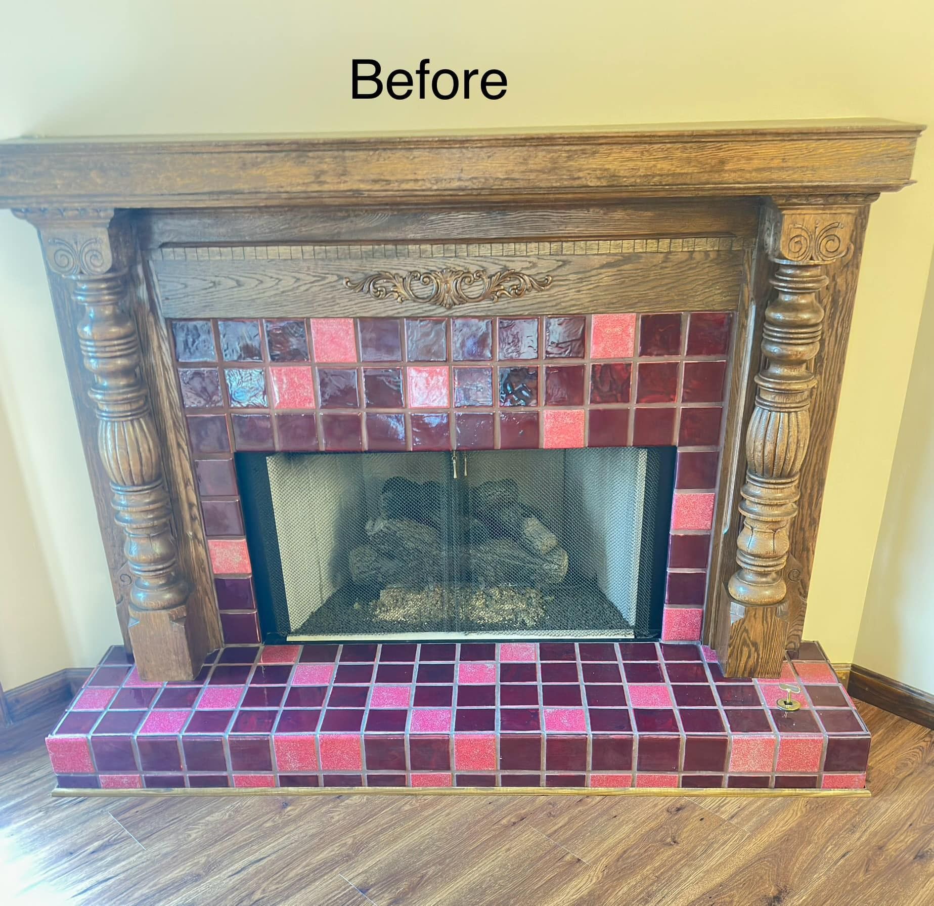 Fireplace with brown wood mantle, red and pink tiles, and decorative pillars.