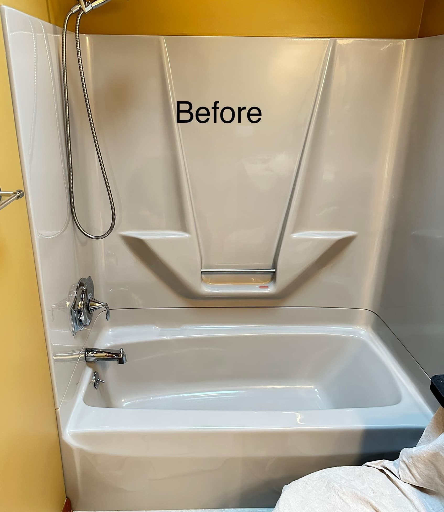 White bathtub with shower fixtures in a bathroom, labeled 