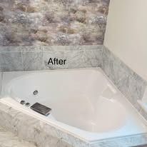 White jacuzzi tub in marble-tiled bathroom; 