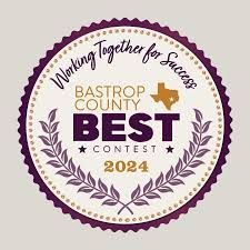 Bastrop County BEST Contest 2024 award seal, purple and beige with text, a Texas outline, and laurel branches.