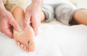 physical therapist massaging foot of patient