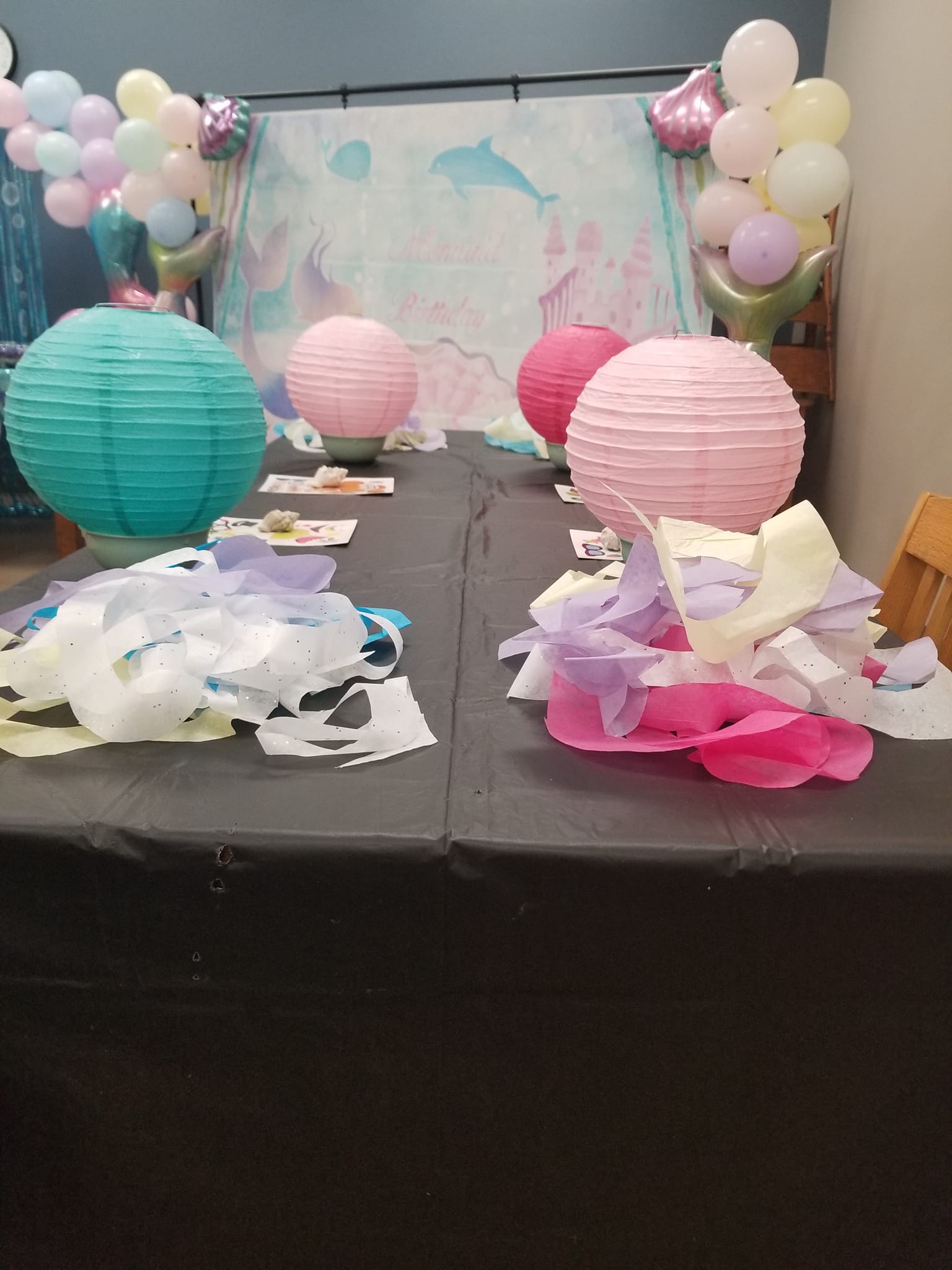 A table with balloons and paper lanterns on it.