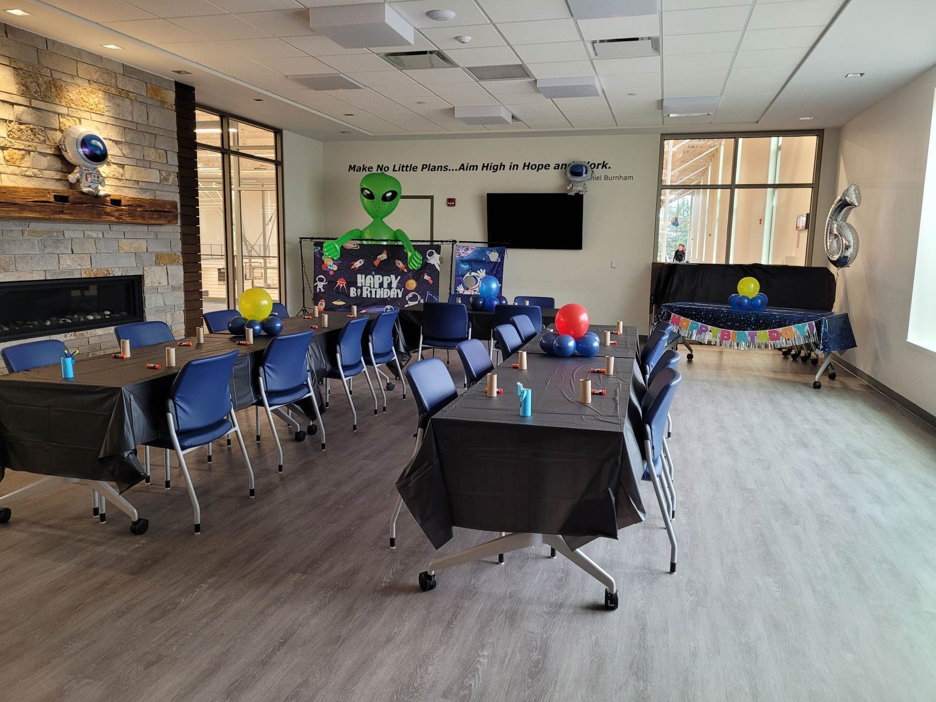 A large room with tables and chairs set up for a party.