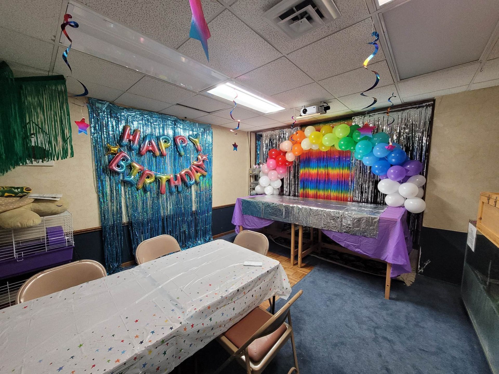 A room with a table and chairs decorated for a birthday party.