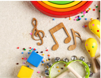 Wooden musical notes, maracas, a tambourine, colorful blocks, and small beads arranged on a light-colored surface.
