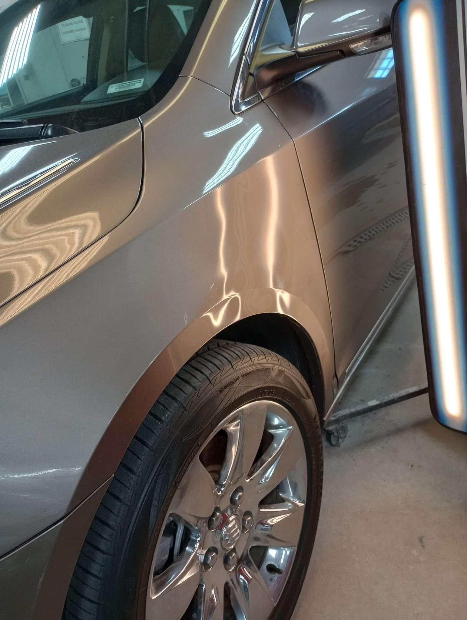 A car is sitting in a garage next to a light.