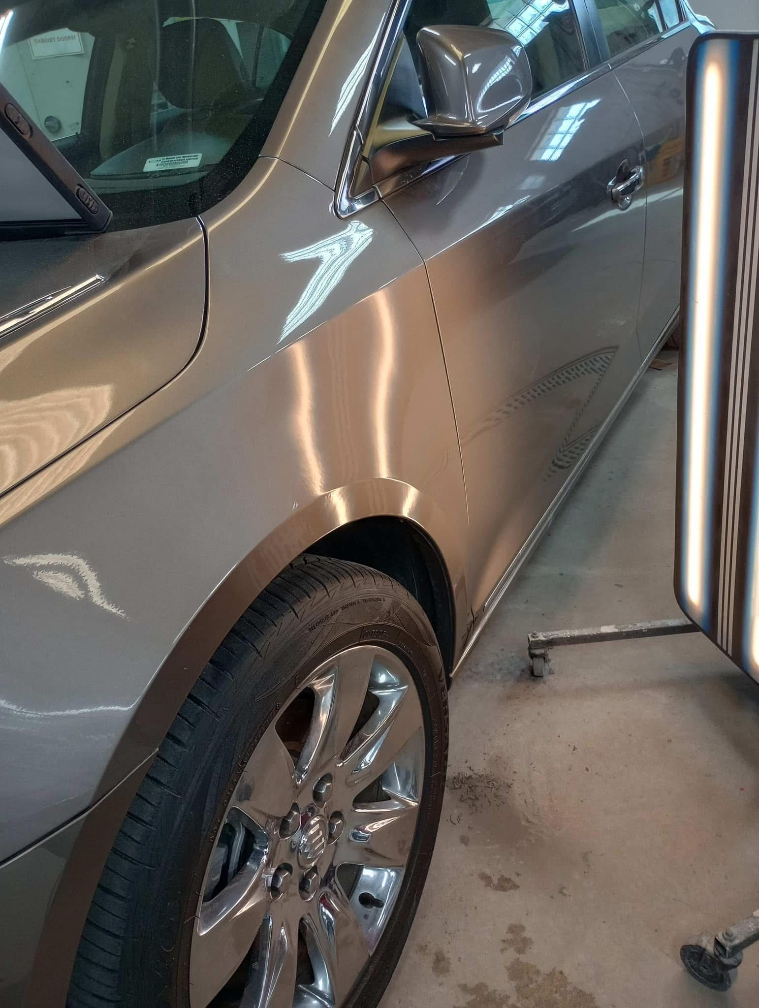 A car is sitting in a garage next to a light.