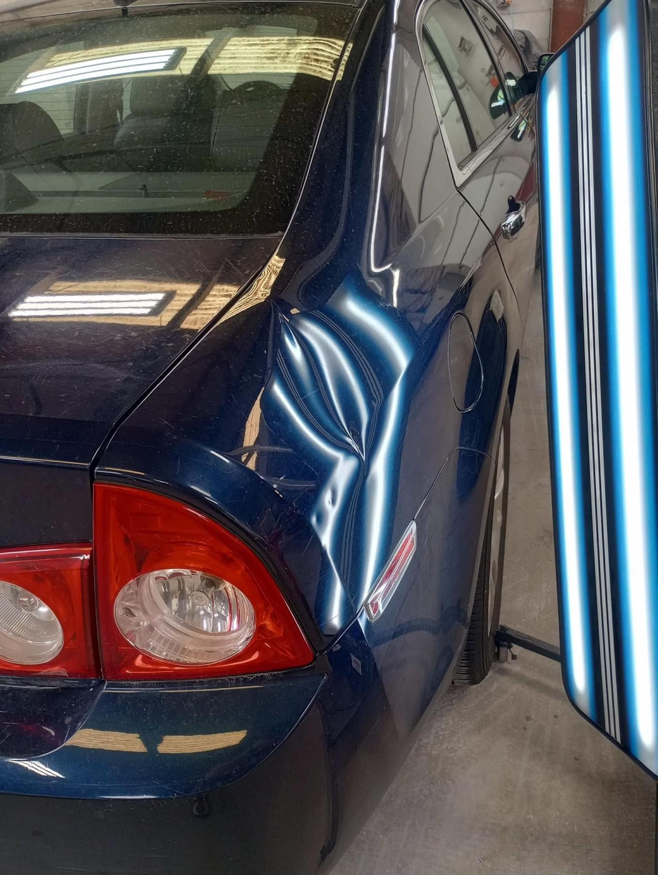 A blue car with a damaged side