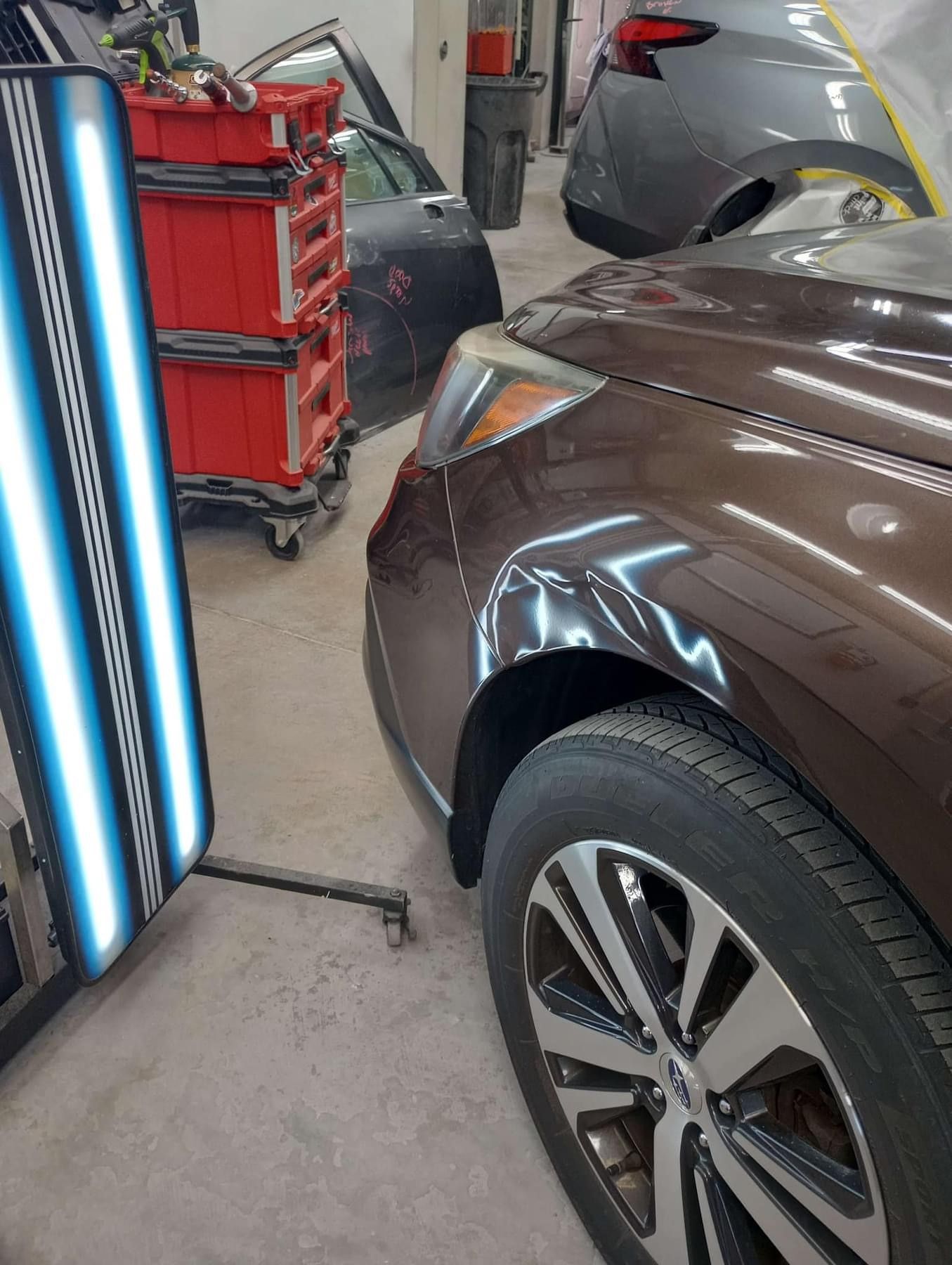 A brown car with a damaged panel
