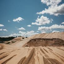 There are many tire tracks in the sand in the desert.