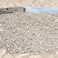A pile of gravel is sitting on top of a pile of sand.