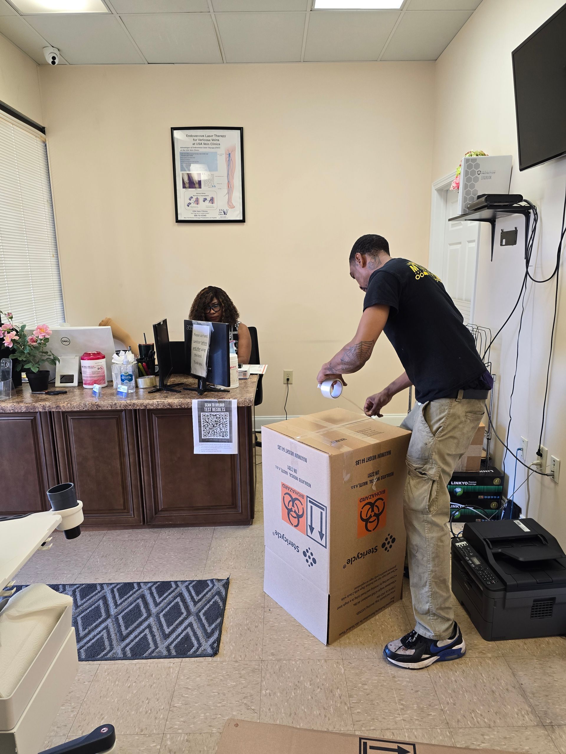 Man packing box and woman sitting at desk