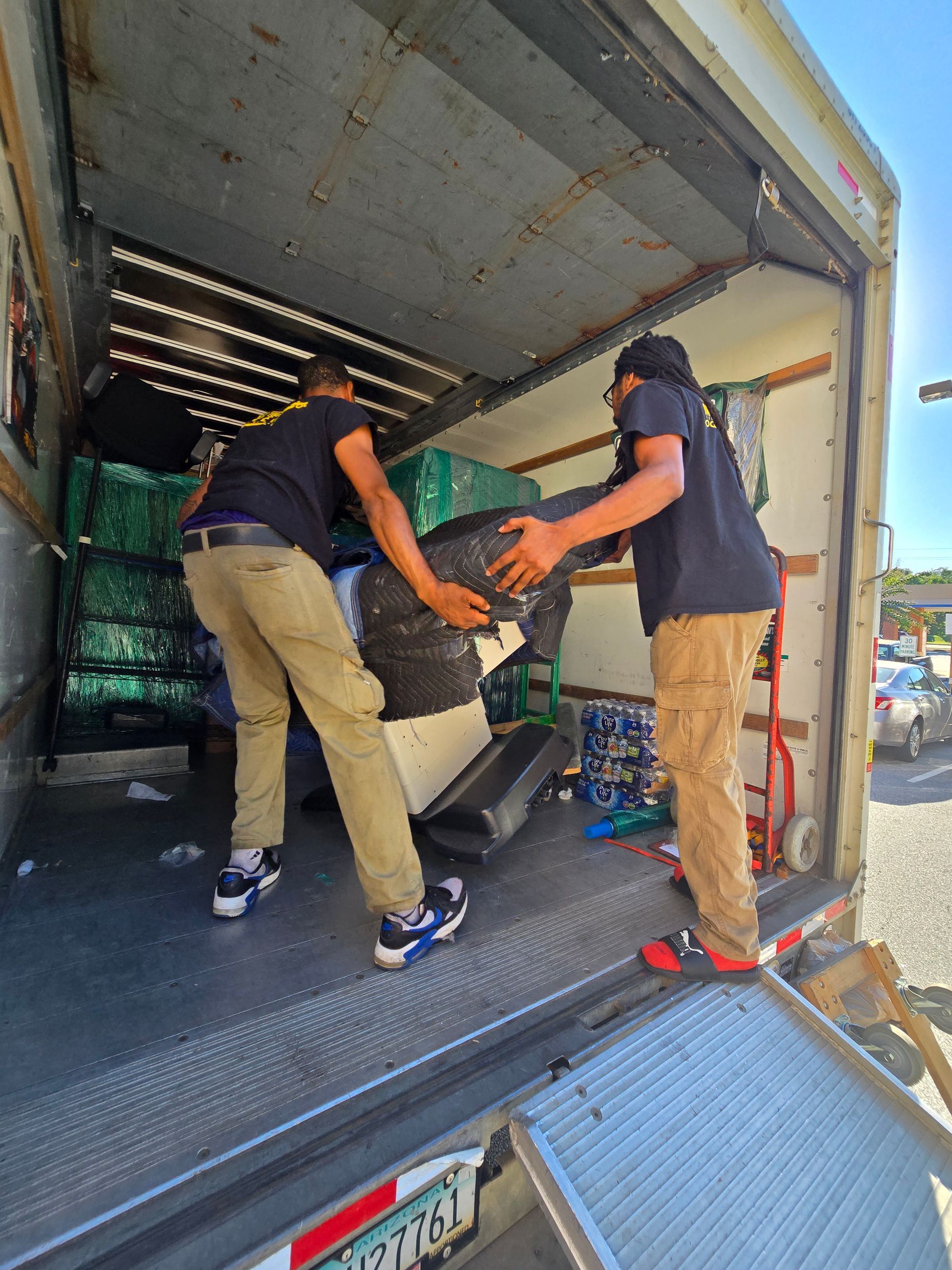2 men moving items out of truck