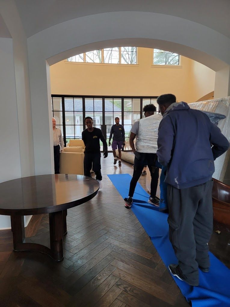A group of people are moving furniture in a living room.