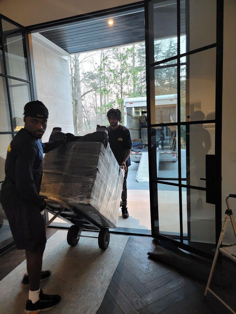 Two men are carrying a large piece of furniture on a dolly.