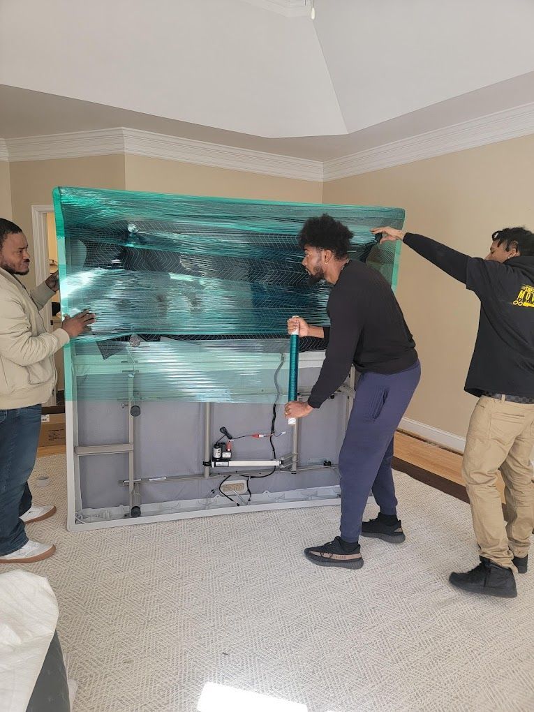 A group of men are moving a television in a living room.