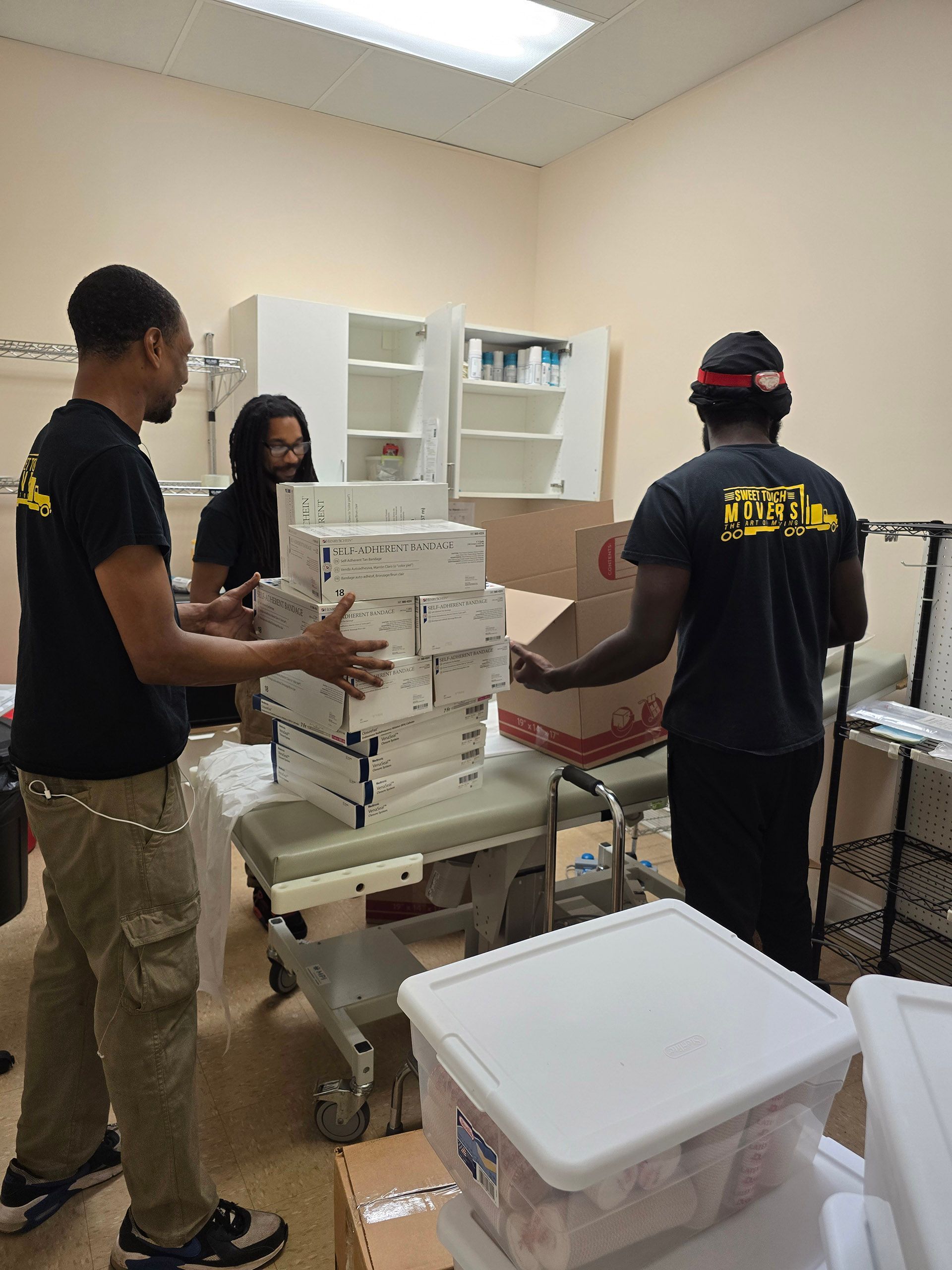 A group of people are moving boxes in a room