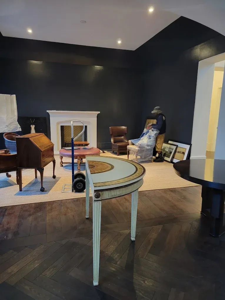 Room with dark walls, fireplace, furniture, and a half-circle table in the foreground.