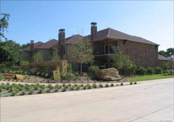 Stone entrance to an apartment complex. Sign says