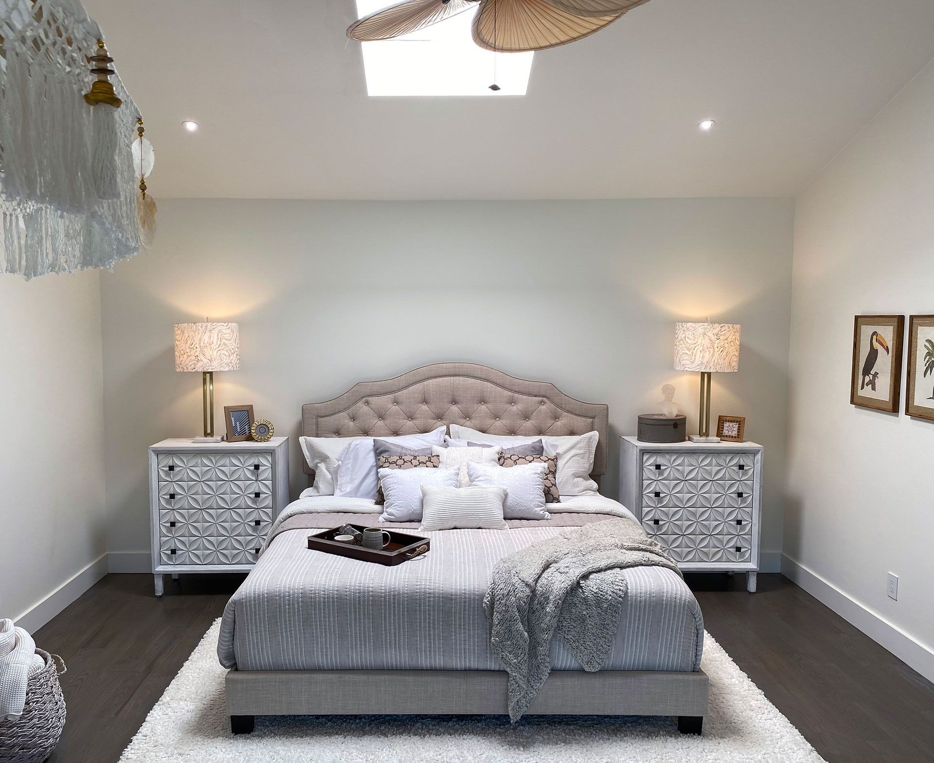 Bedroom with bed, nightstands, lamps, and decorative accents; neutral colors.
