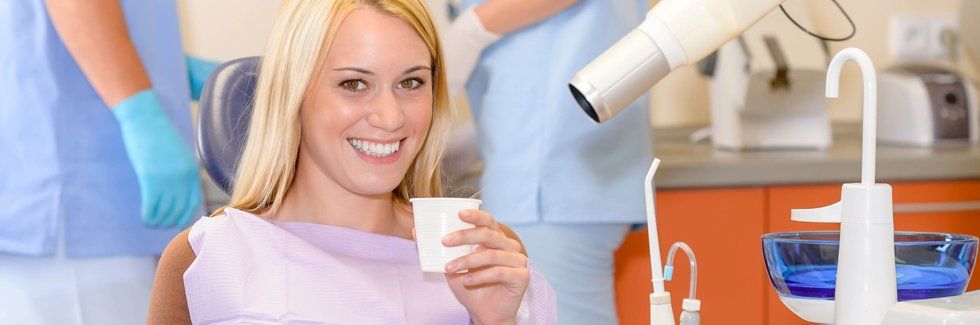 Patient holding a cup inside dental clinic