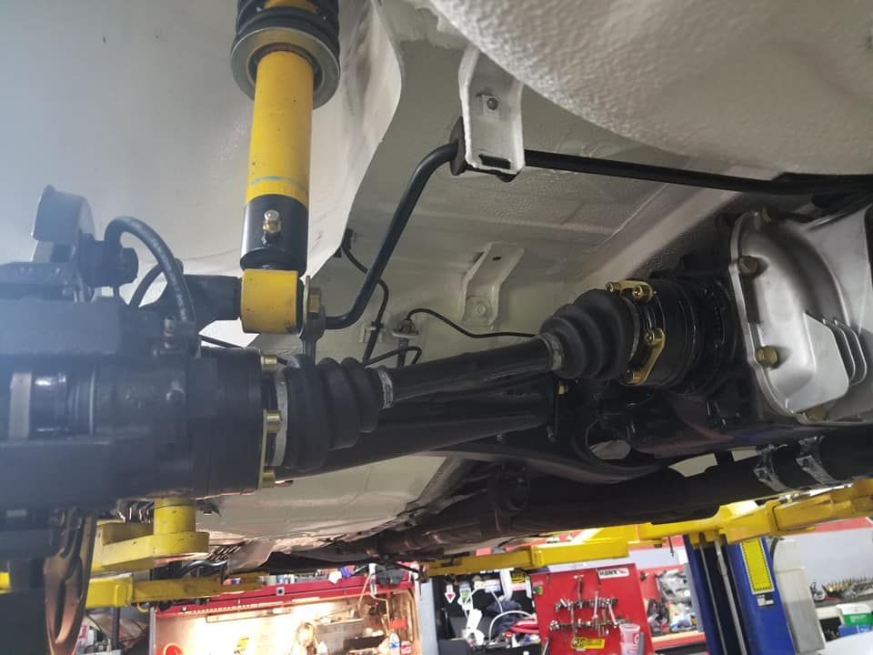 A car is sitting on a lift in a garage.