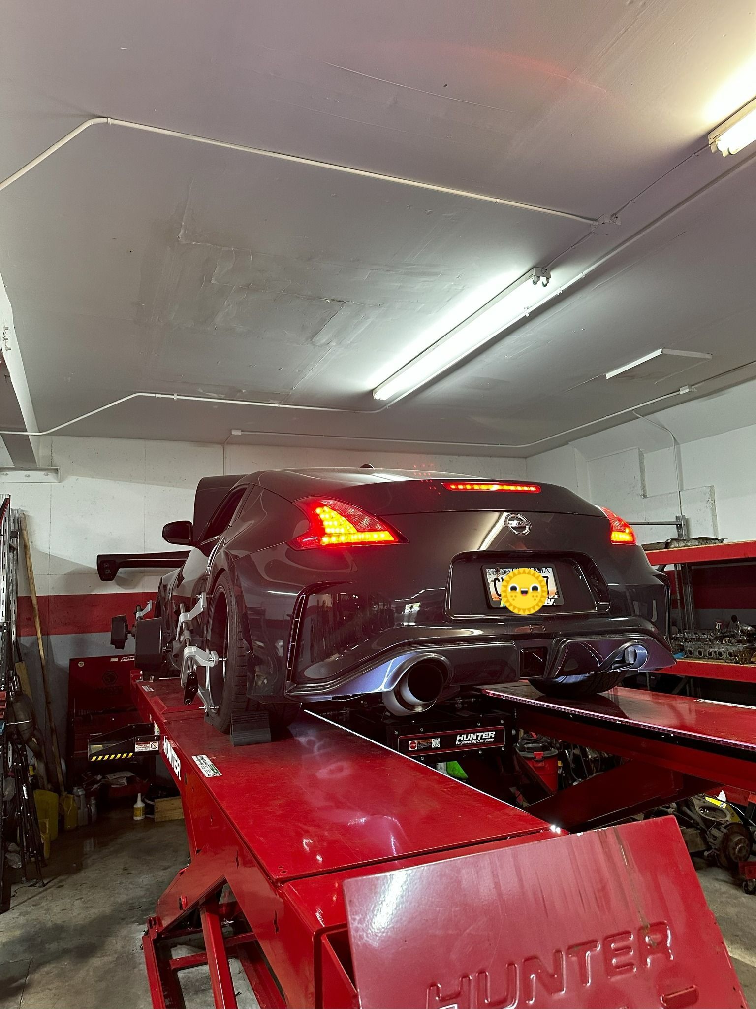 A car is sitting on a lift in a garage.