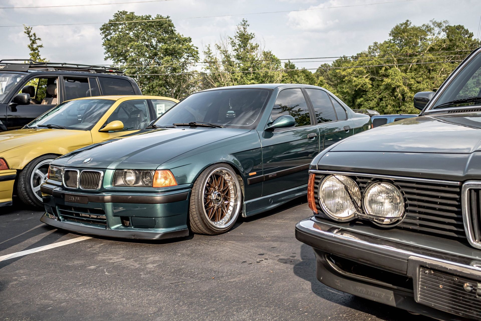 A group of cars are parked next to each other in a parking lot.