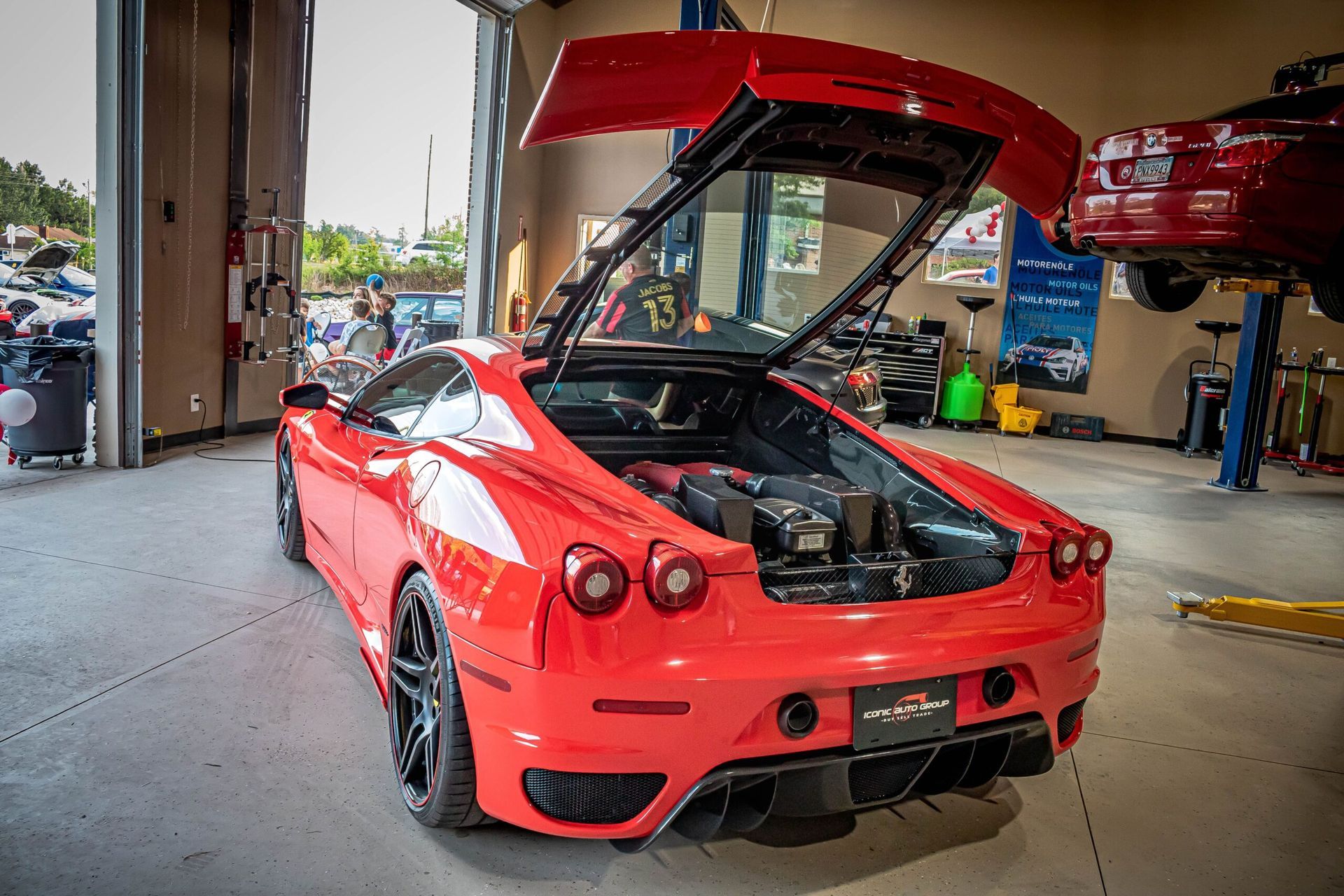 A red sports car with the trunk open