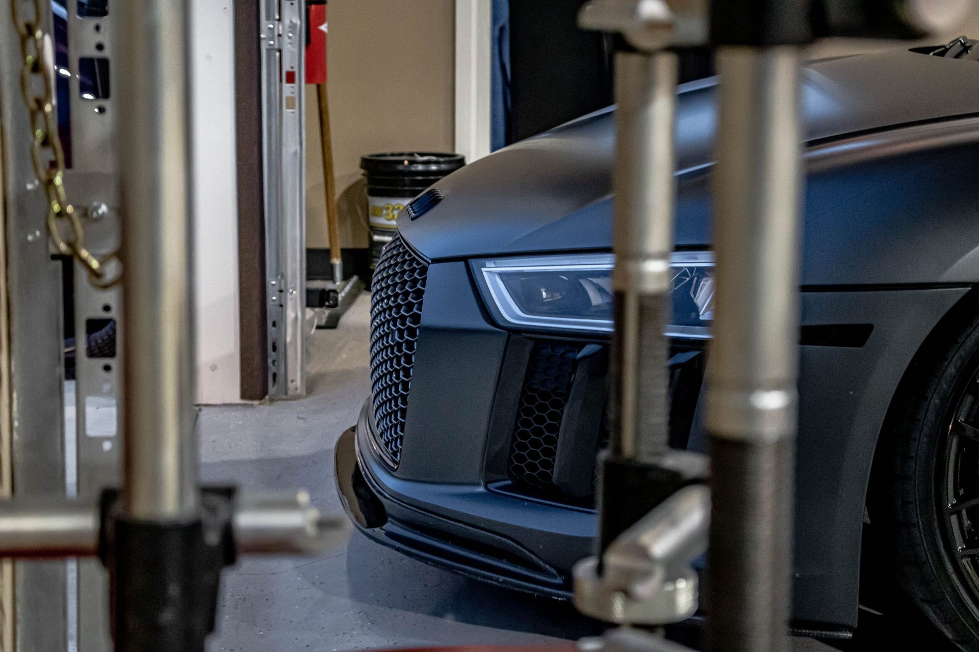 A car is parked in a garage next to a machine.