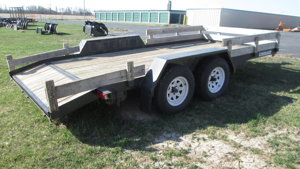 A trailer is parked in a grassy field.