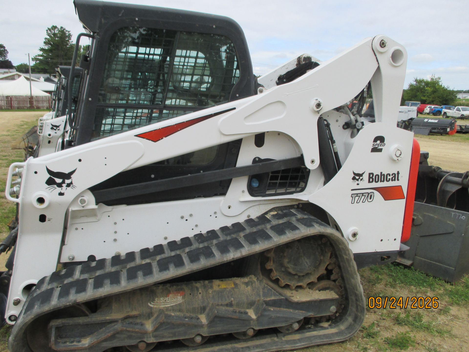 White Bobcat compact track loader with bucket attachment on a lot