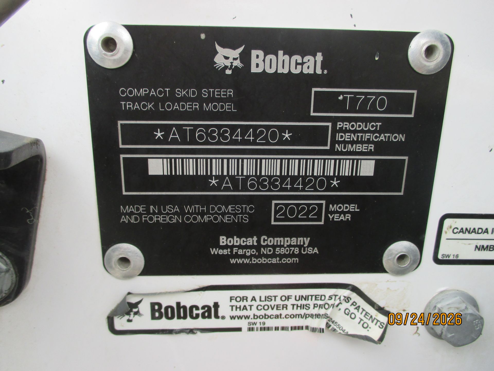 Bobcat skid steer machine identification plate with model and serial number on a black metal tag