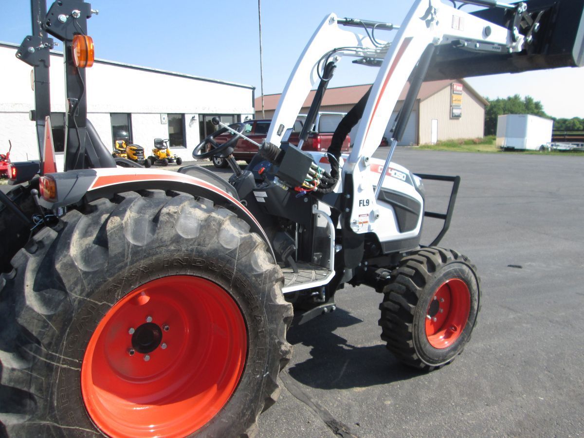 A white and red tractor is parked in a parking lot
