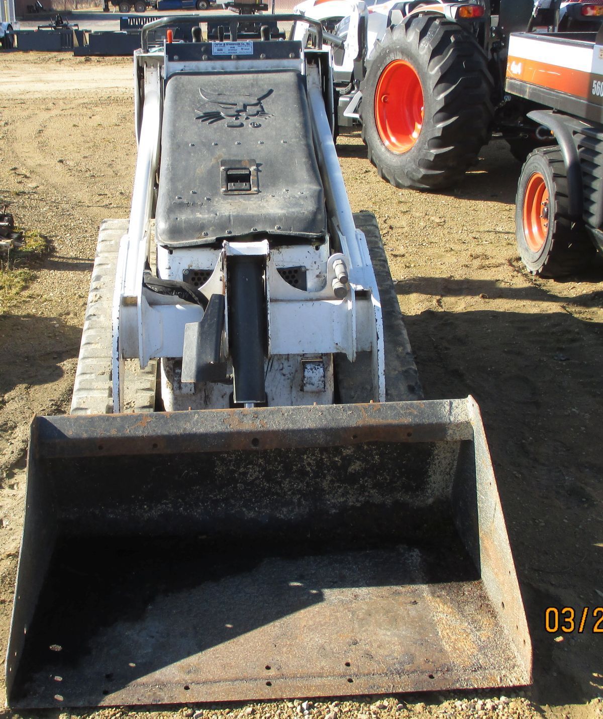 A tractor is parked in the dirt with a photo taken on 03/12