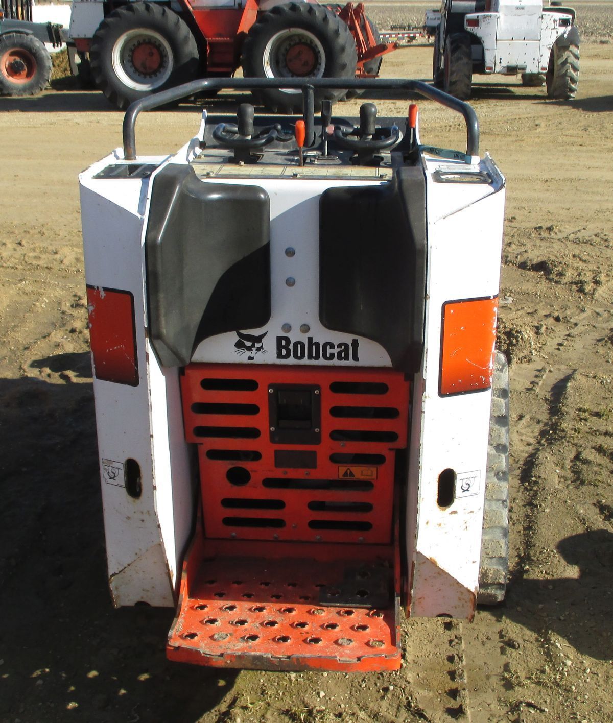 A bobcat tractor is parked in the dirt