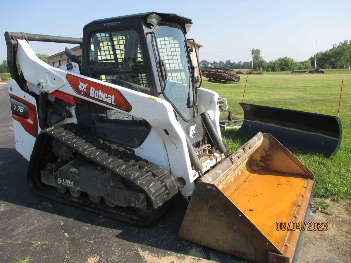 A bobcat tractor is parked on the side of the road