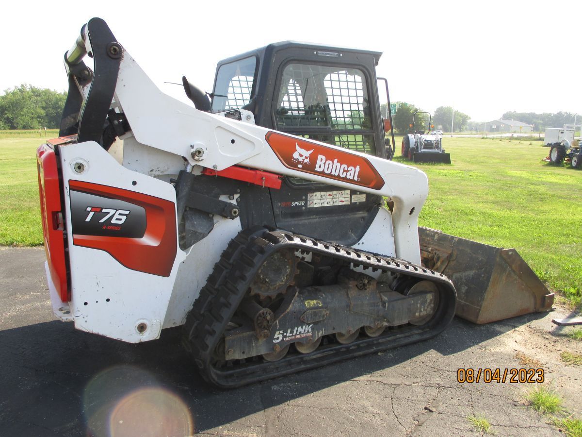 A bobcat track loader is parked on the side of the road.