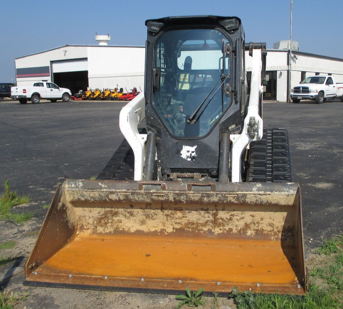 A bobcat tractor is parked in front of a building