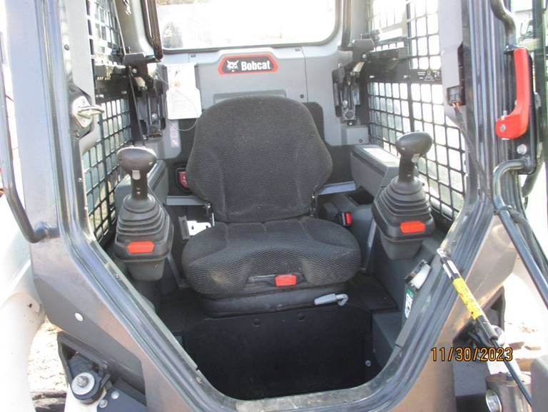 The inside of a bobcat tractor with the door open