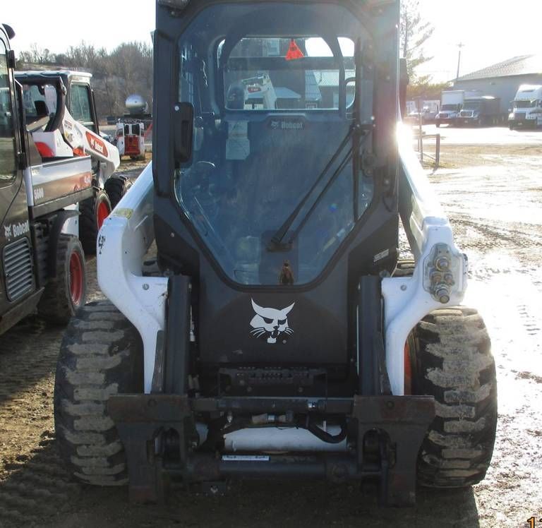 A bobcat skid steer is parked in the dirt