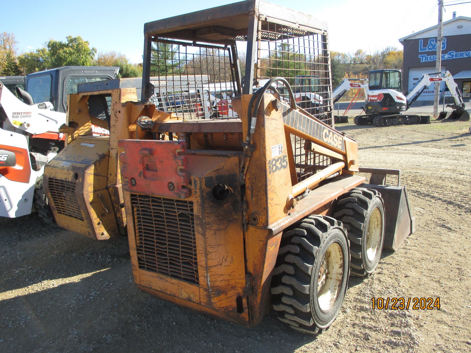 A small tractor is parked in a dirt field.