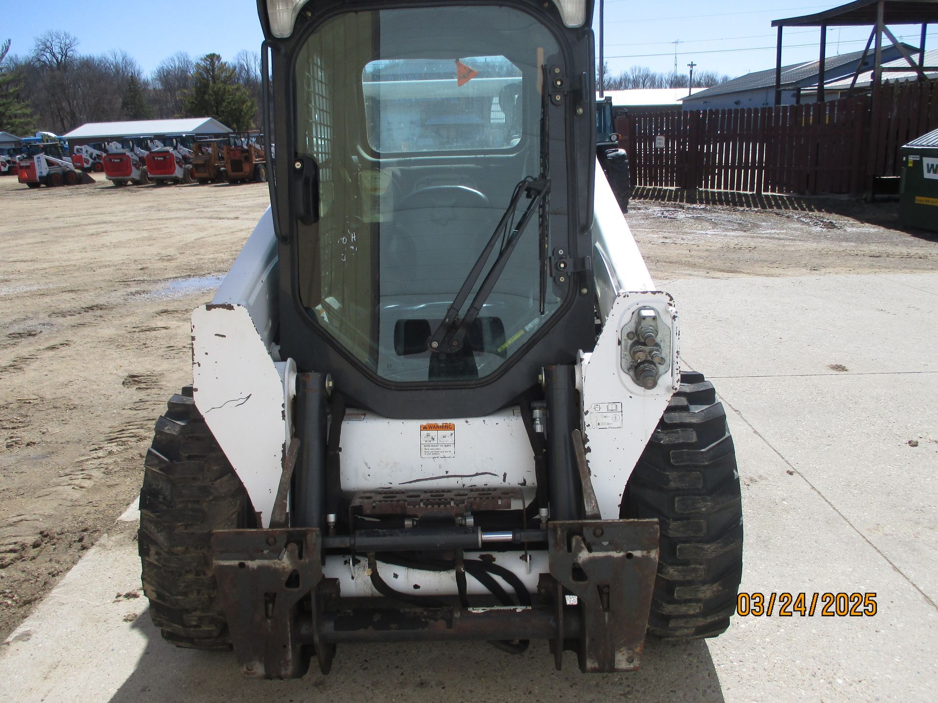 A bobcat is parked on the side of the road
