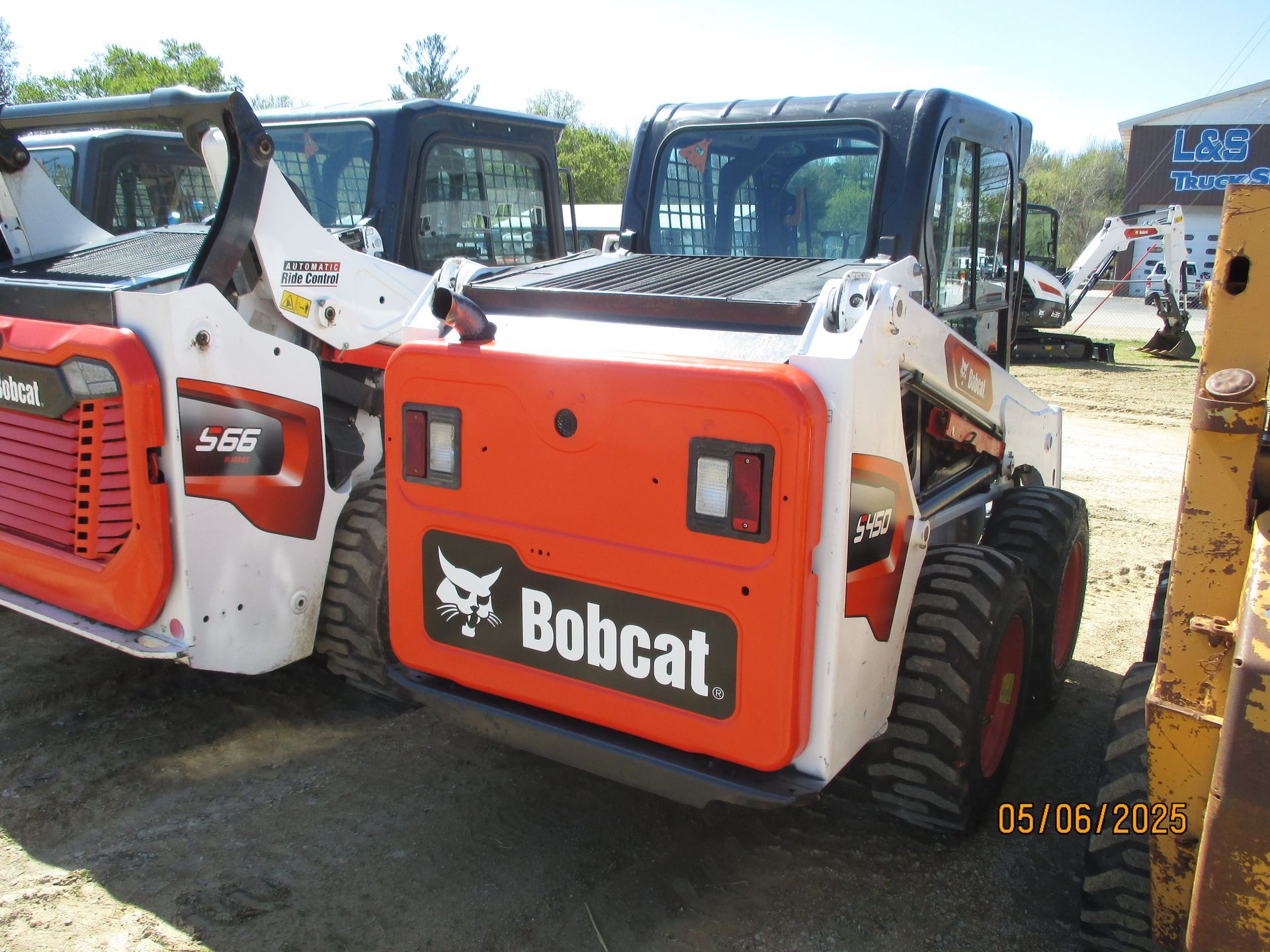 A bobcat tractor is parked next to another bobcat tractor