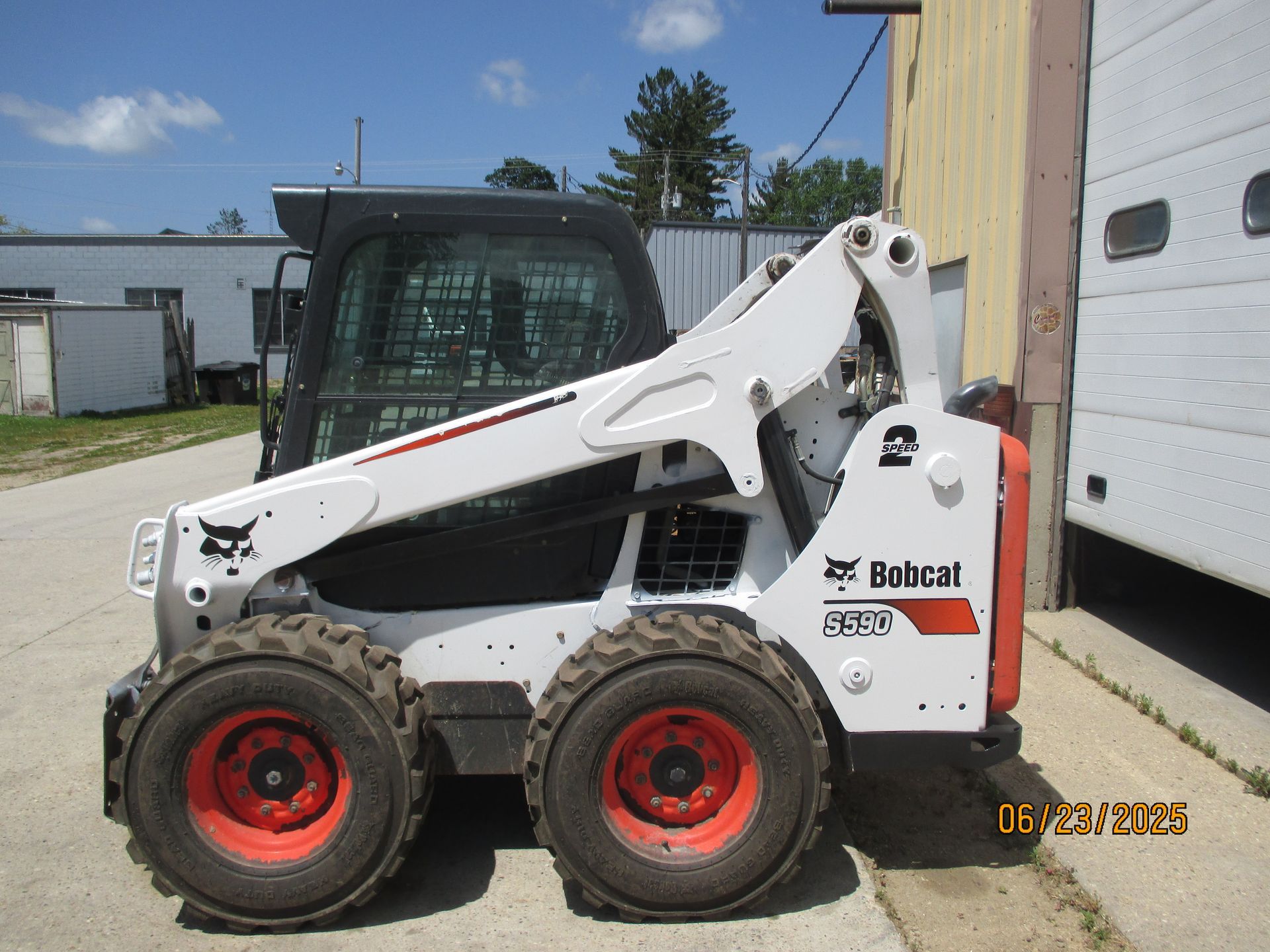 A bobcat skid steer is parked in front of a building