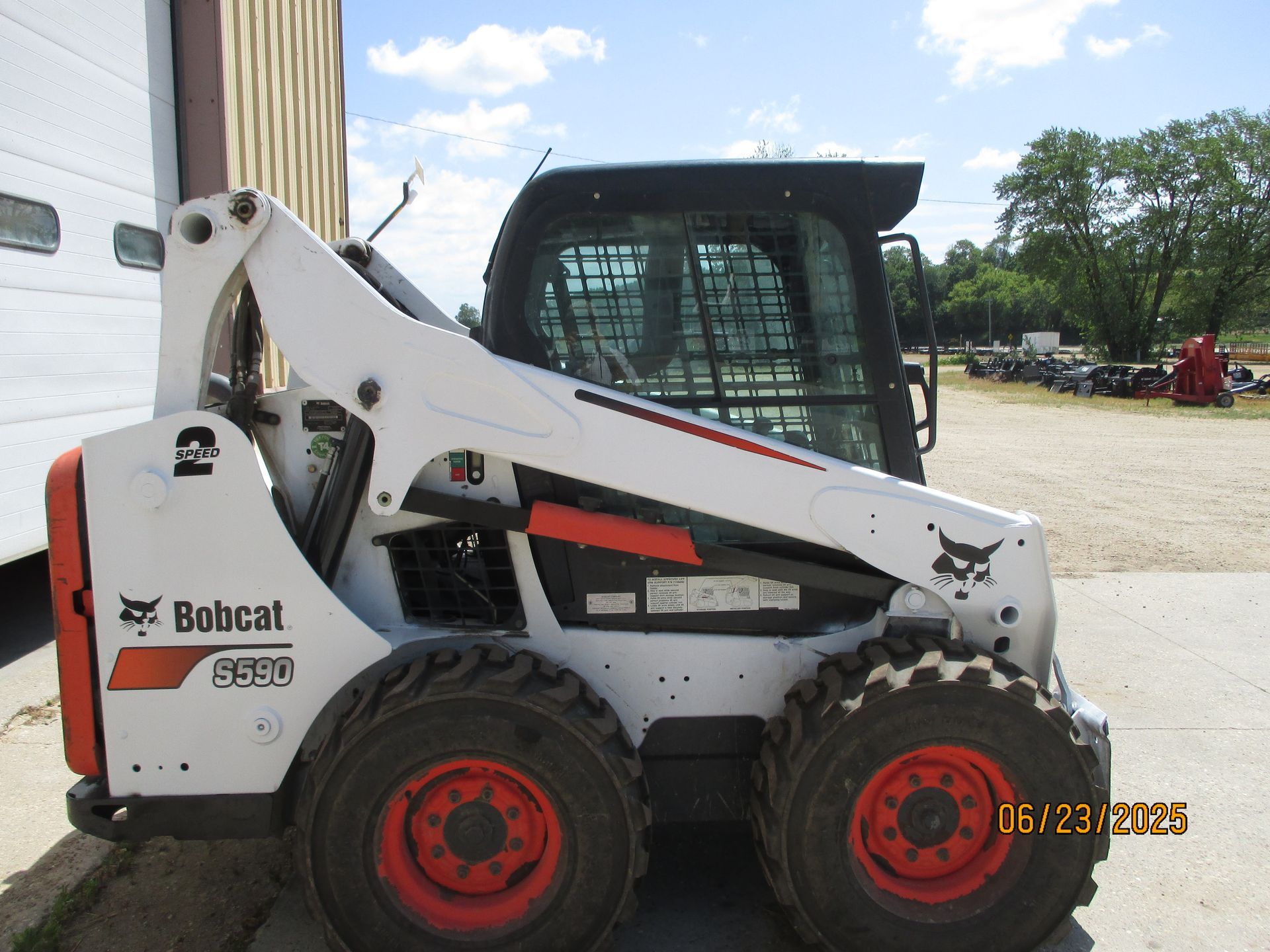 A bobcat skid steer is parked in front of a building