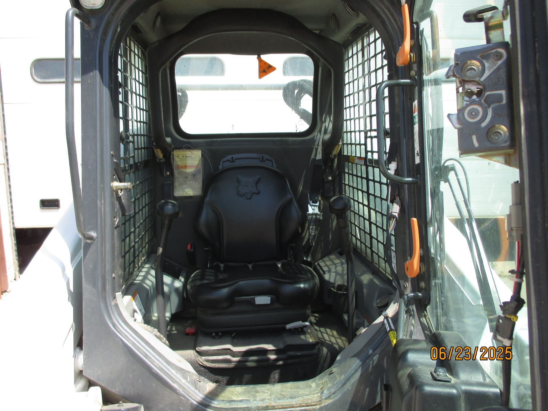 The inside of a skid steer with a smiley face on the seat