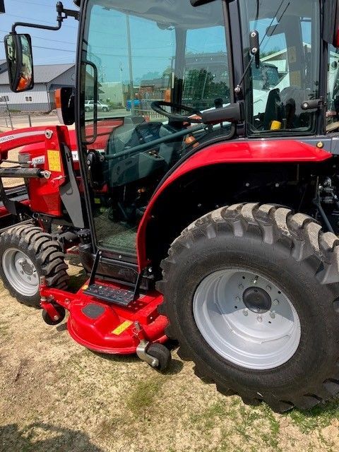 A red tractor with a lawn mower attached to it