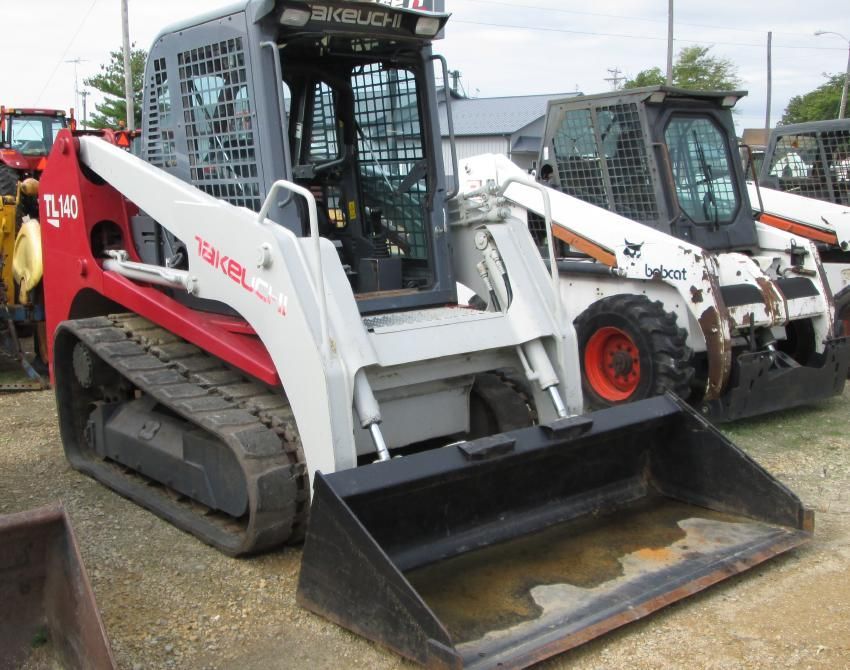 A bobcat skid steer is parked next to another skid steer